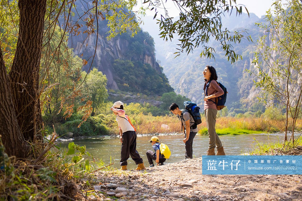 快乐的年轻家庭在河边玩耍