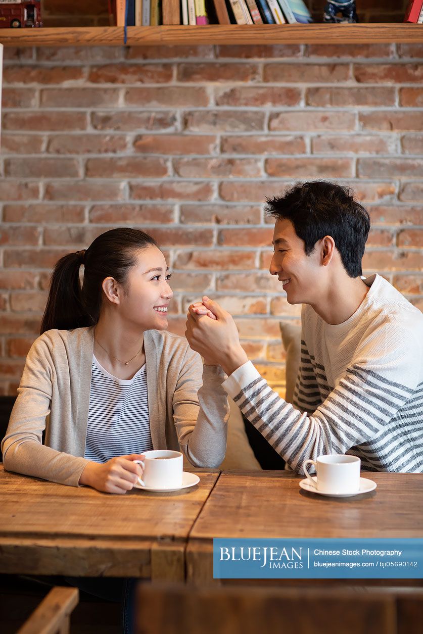 Young Chinese couple dating in coffee shop