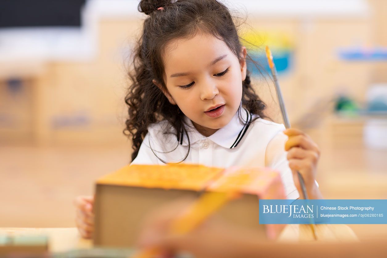 Little girl having art class in classroom