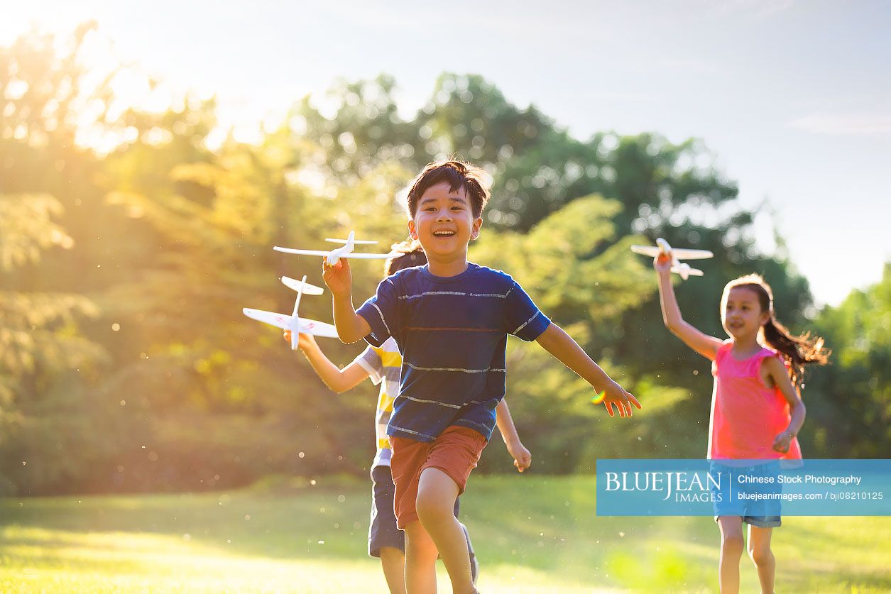Happy Chinese children playing on meadow