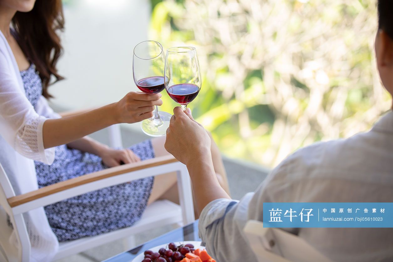 年轻夫妇在露台喝红酒
