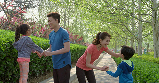 Happy young Chinese family exercising in park,4K