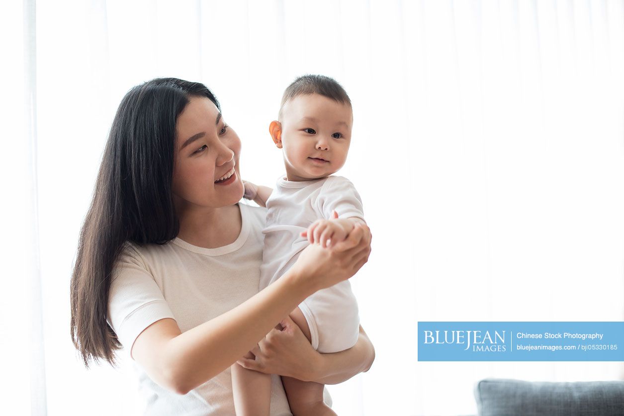 Happy Chinese mother and cute baby at home