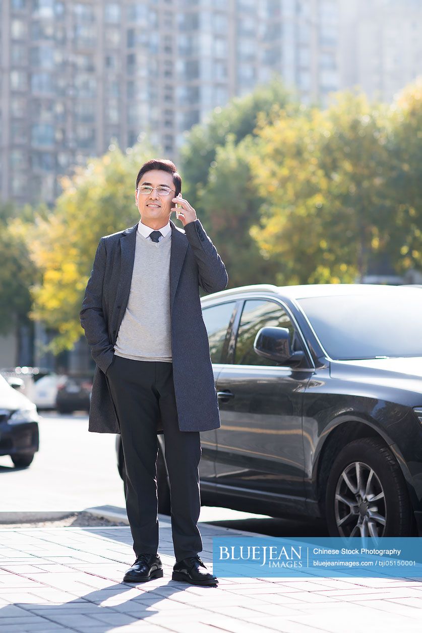 Confident Chinese businessman talking on the phone