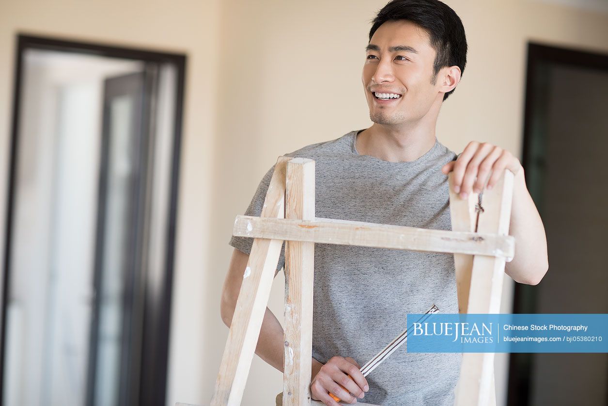 Young Chinese man working on home renovation