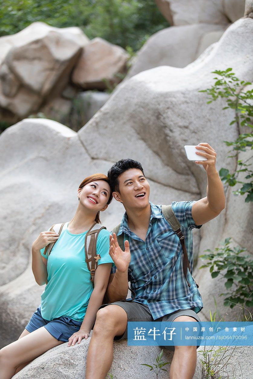 快乐的年轻情侣在户外使用手机