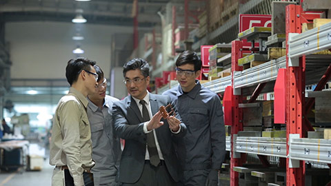 Confident Chinese manager and engineers talking in factory,HD