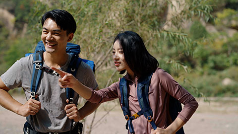 Happy young Chinese family hiking outdoors