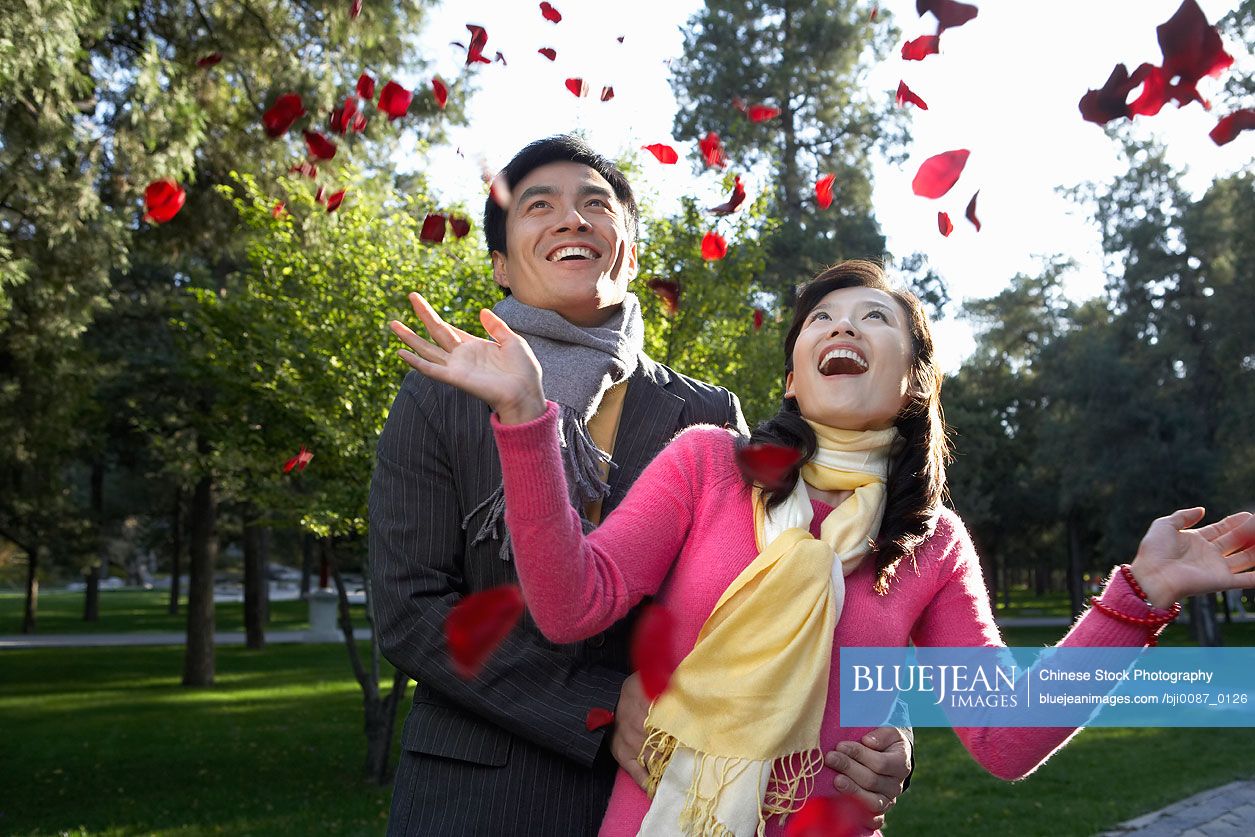 Young Chinese Couple Throwing Petals In The Air