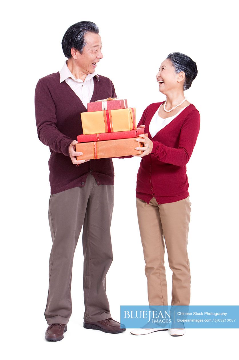 Cheerful senior Chinese couple holding gift boxes-High-res stock photo ...