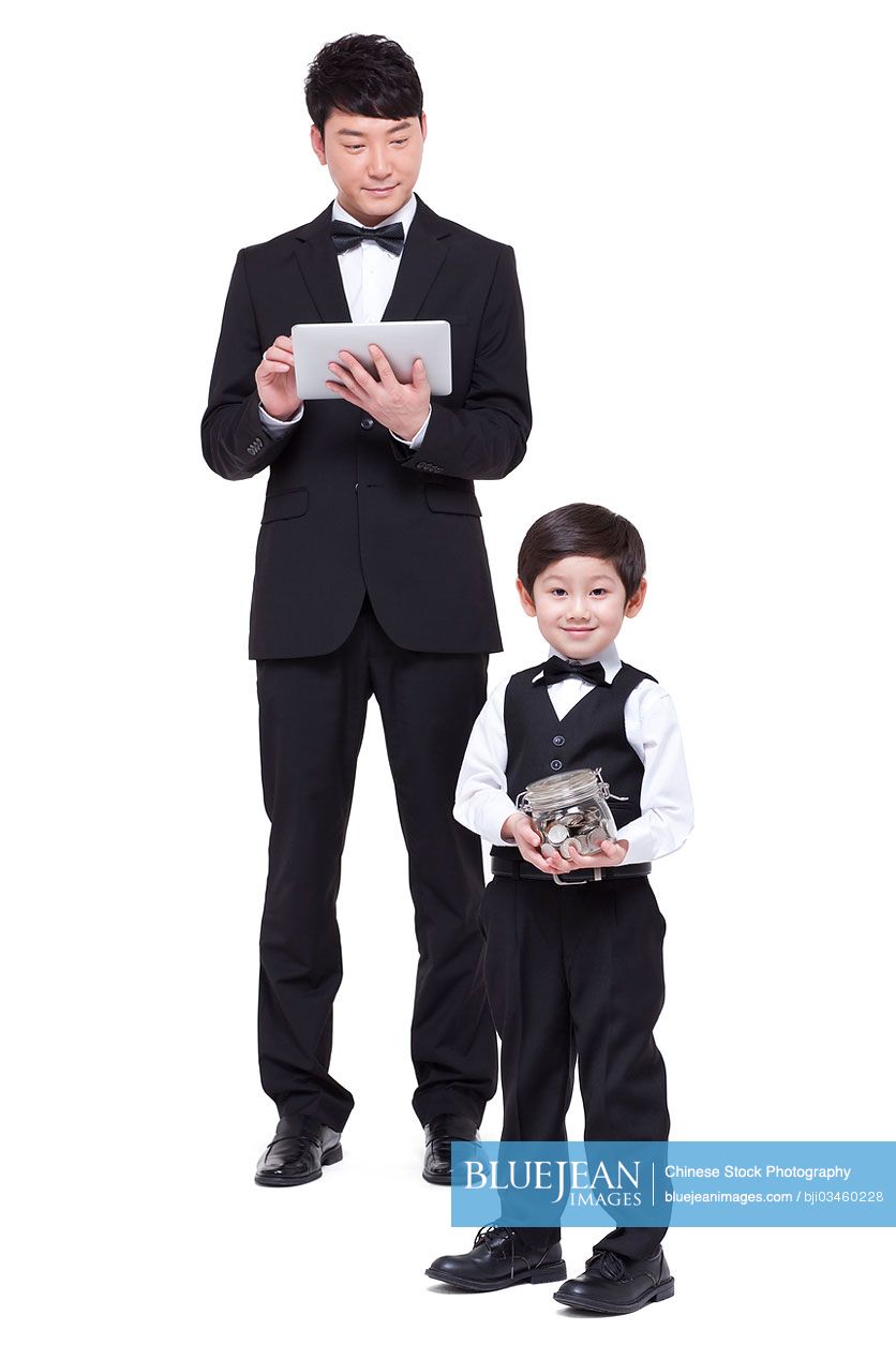 Young Chinese family with piggy bank and digital tablet