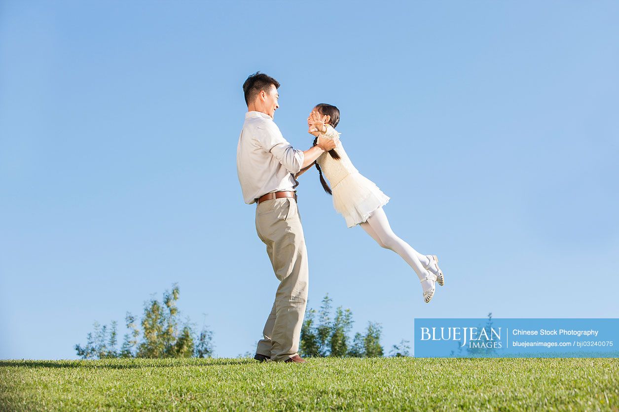 chinese-father-and-little-daughter-having-fun-in-a-park-high-res-stock