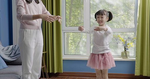 Mom and daughter dancing casually at home