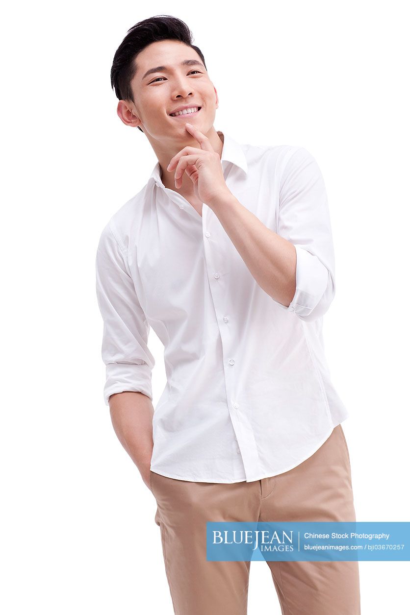 Happy Chinese young man with hand on chin