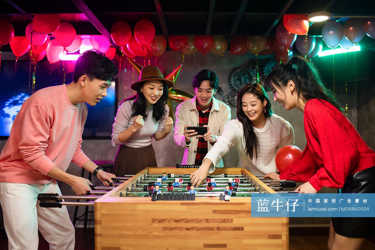 快乐的年轻人玩桌上足球