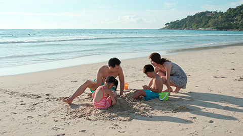 快乐的年轻家庭在海边玩耍