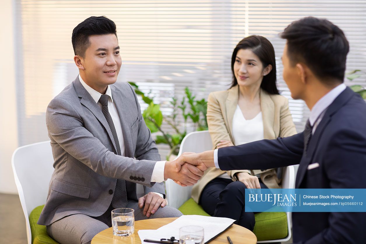 Chinese business people shaking hands in office