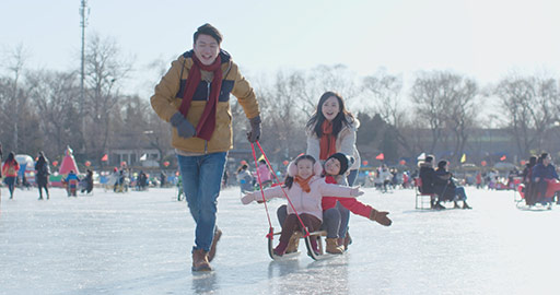 Happy young Chinese family having fun on ice,4K