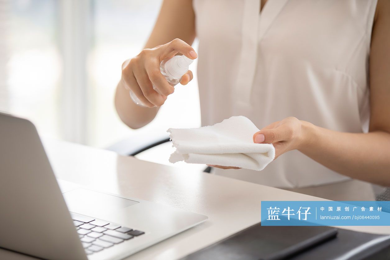 年轻的商务女士在办公室使用消毒液杀菌消毒