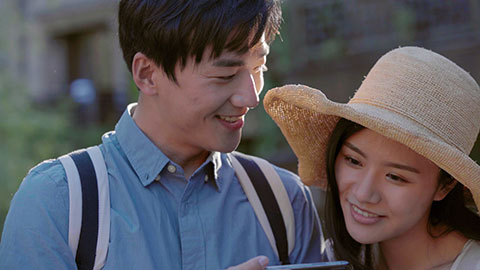 Happy young Chinese couple using smartphone outdoors,4K