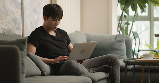 年轻男子在家使用笔记本电脑