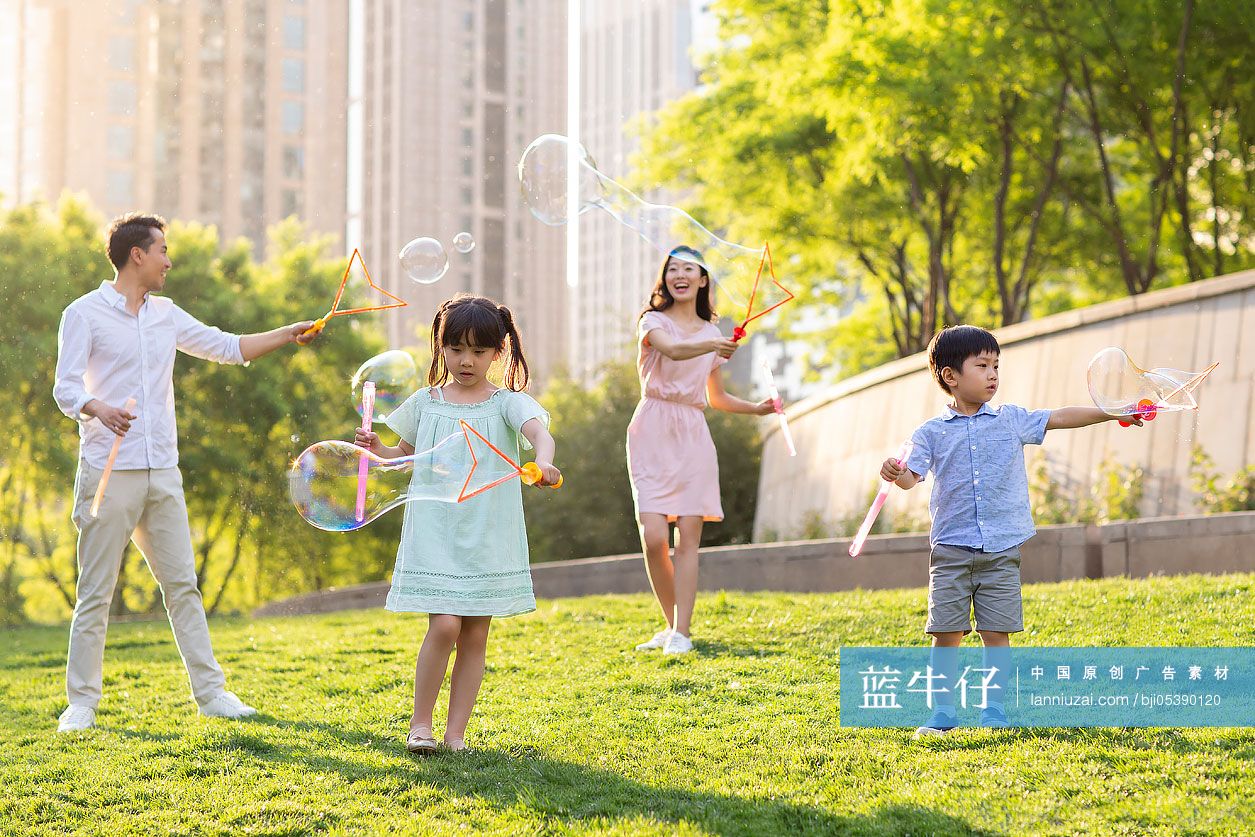 快乐的年轻家庭在公园玩泡泡