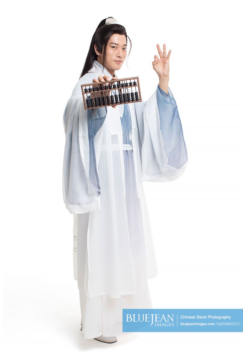 Young Chinese man in ancient costume holding an abacus