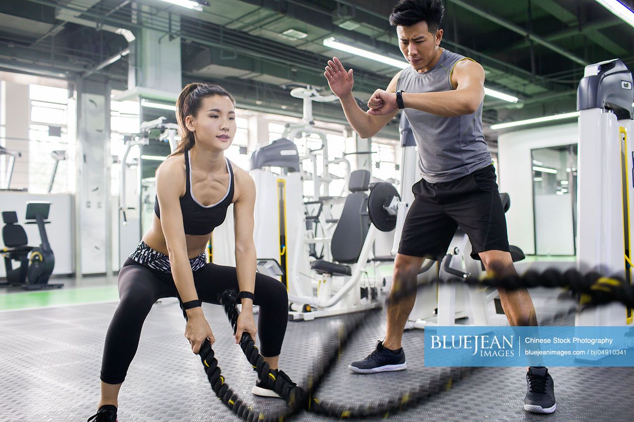 Young Chinese woman working with trainer at gym-High-res stock photo ...