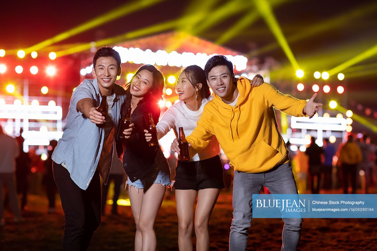 Happy young Chinese friends at music festival