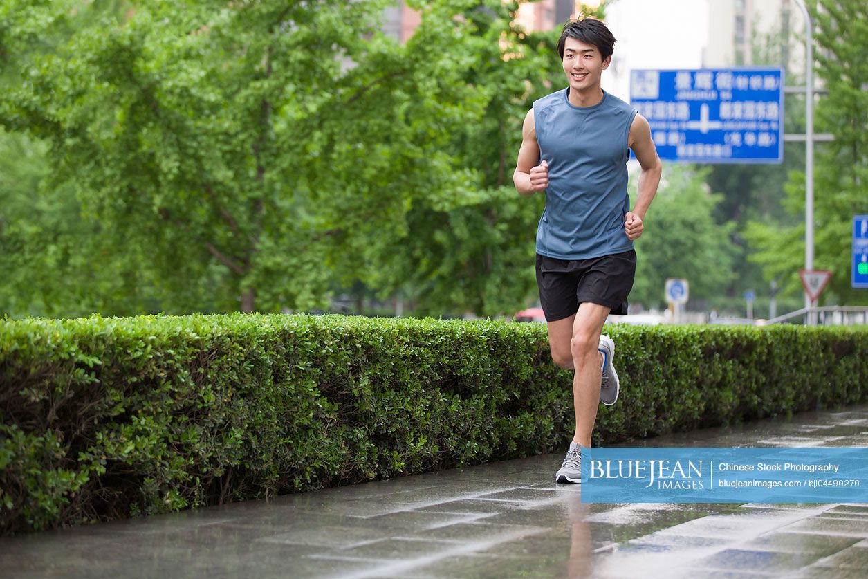 Young Chinese man running outside