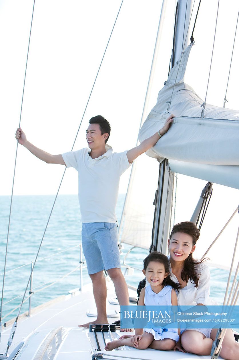 Happy Chinese family on a sailboat