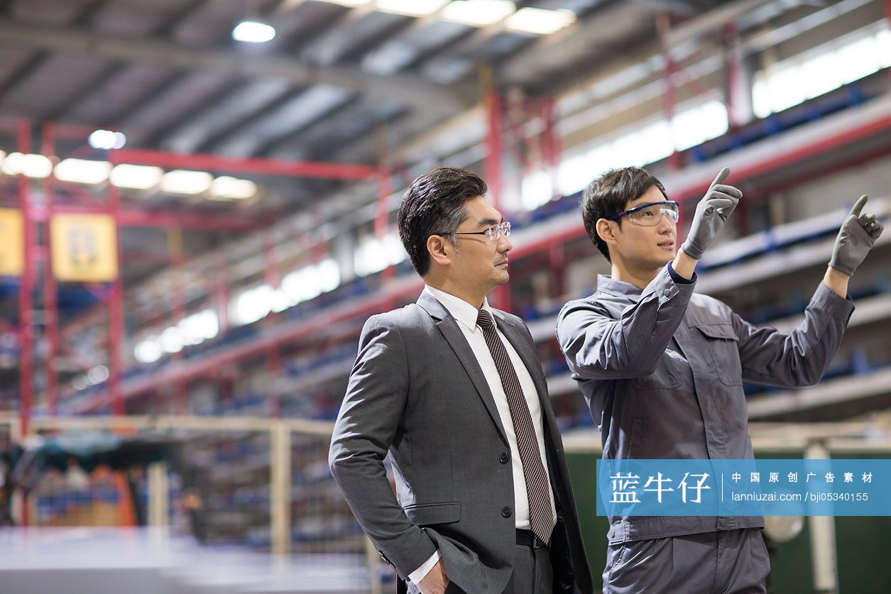 商务男士和工程师在工厂讨论工作