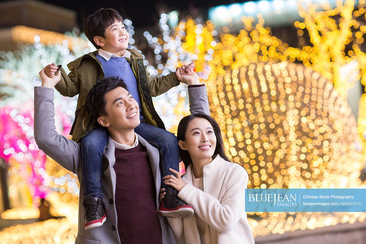 Cheerful young Chinese family looking at view