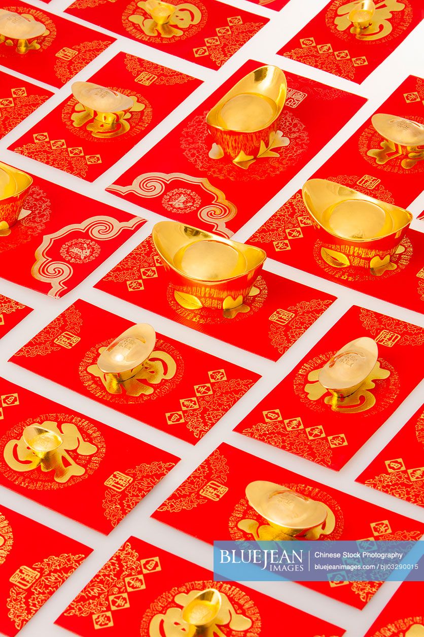Chinese traditional currency gold yuanbao ingots and red pockets for Chinese New Year