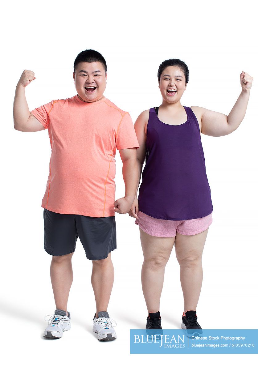 Overweight young Chinese couple punching the air