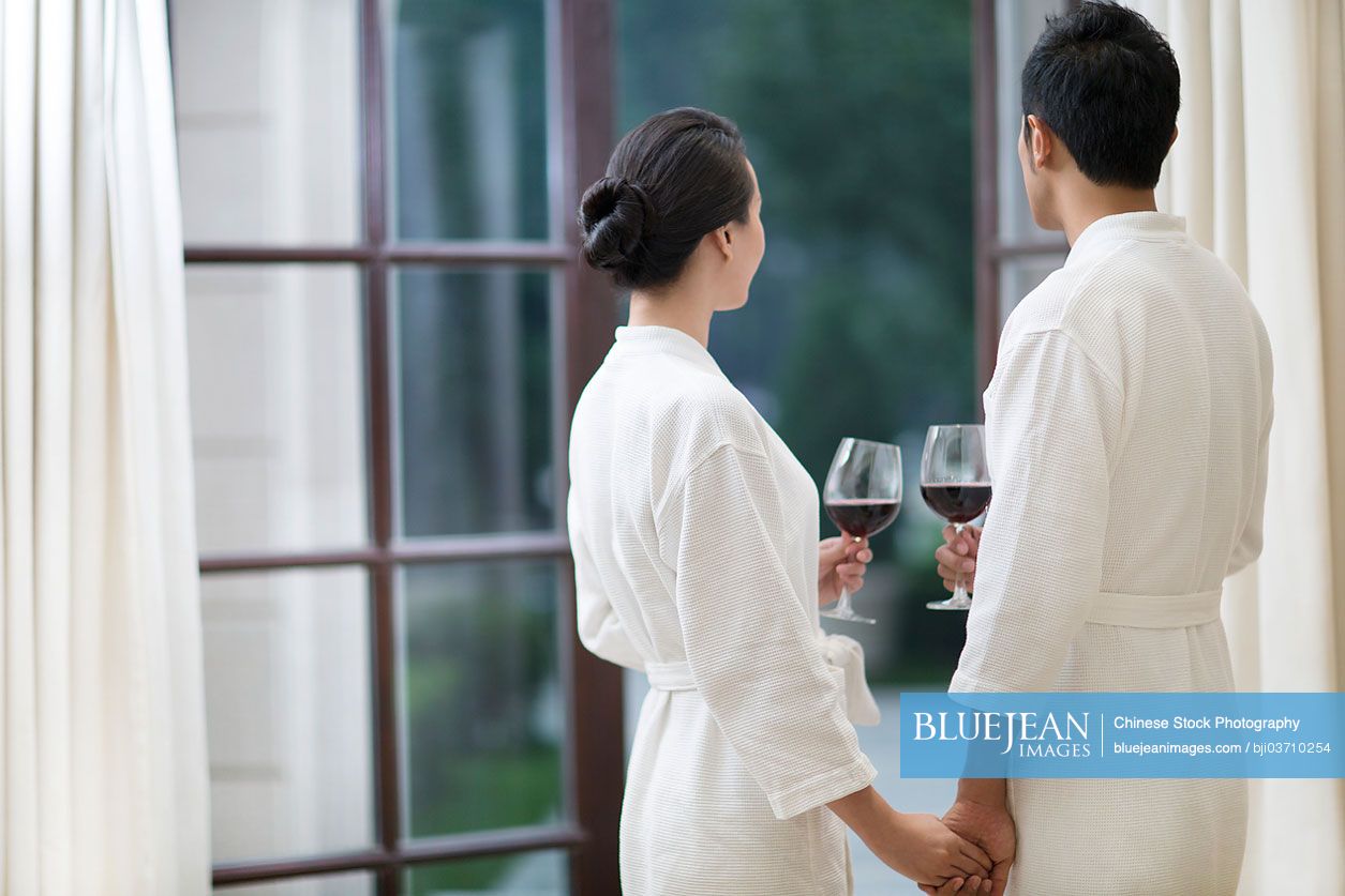 Loving Chinese couple with wine in a luxury hotel