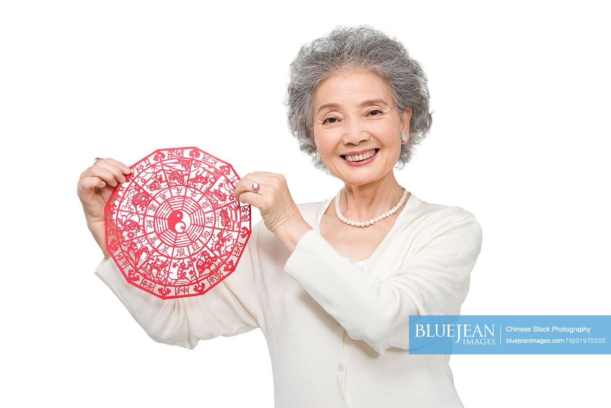 Senior Chinese woman holding traditional paper cutting