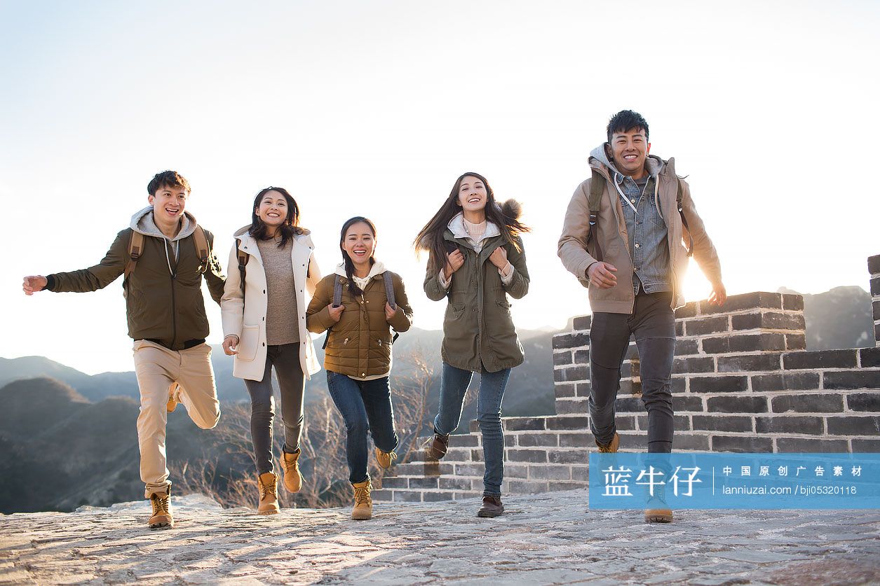 Happy young Chinese friends enjoying winter outing on the Great Wall