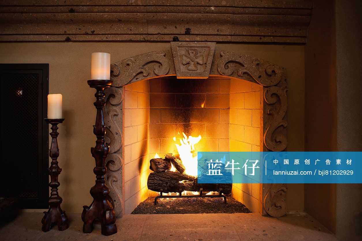 Close-up of candlestick holders besides lit fireplace in living room at home; Scottsdale; USA