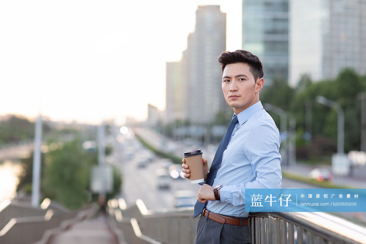 年轻商务男士拿着一杯咖啡