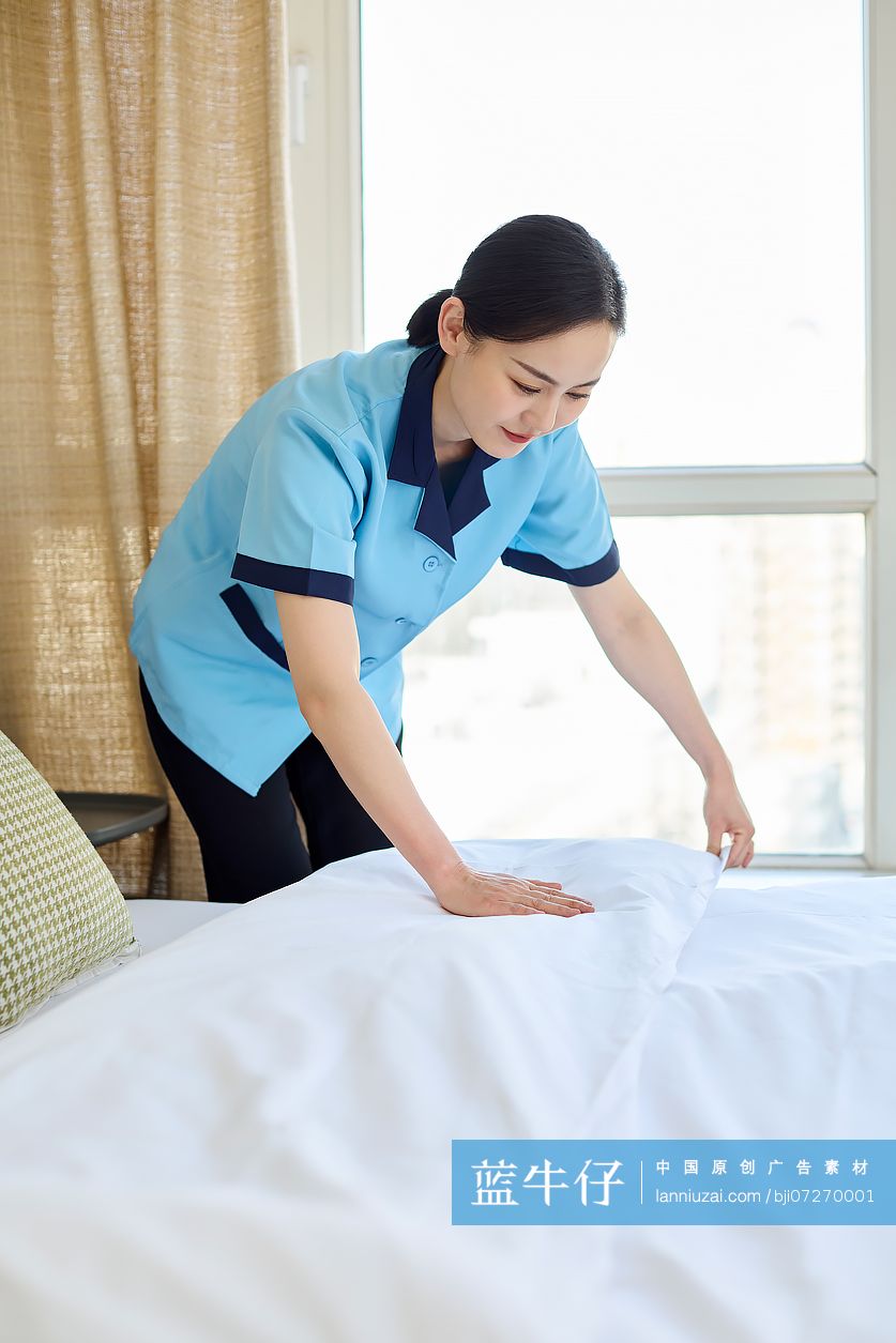 家政人员整理卧室床铺
