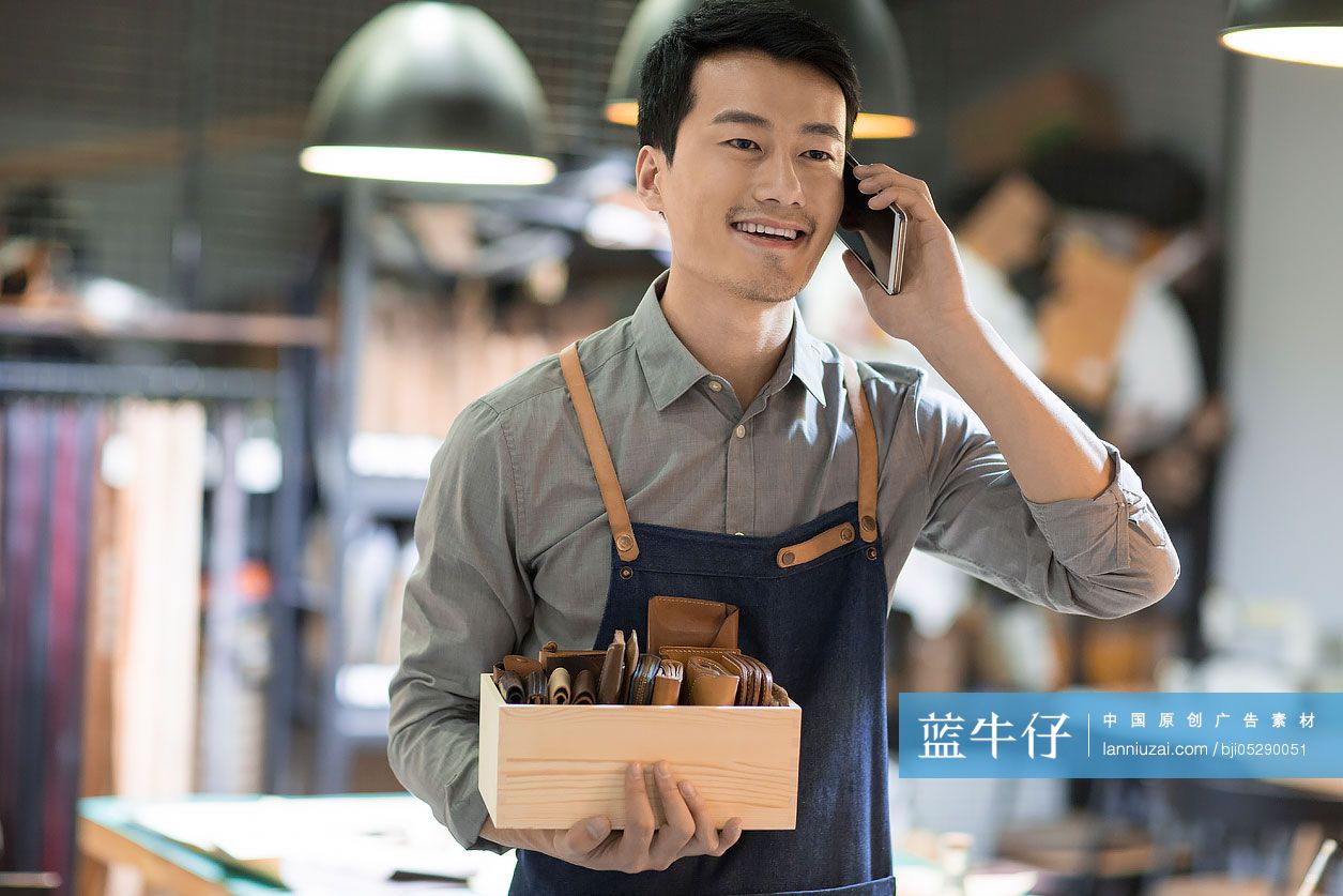 手工皮具匠人在工作室里打电话