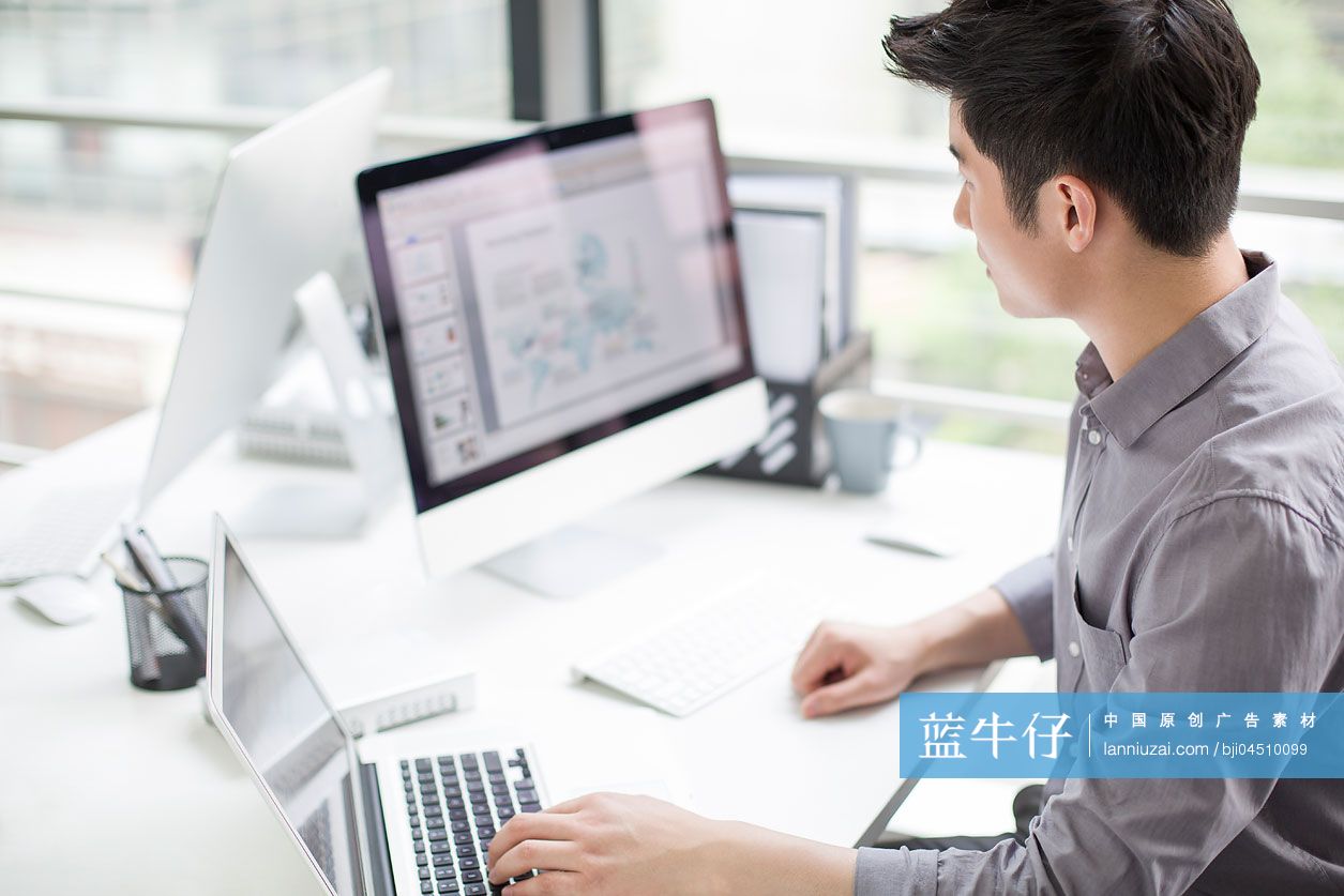 年轻商务男士在办公室使用笔记本电脑