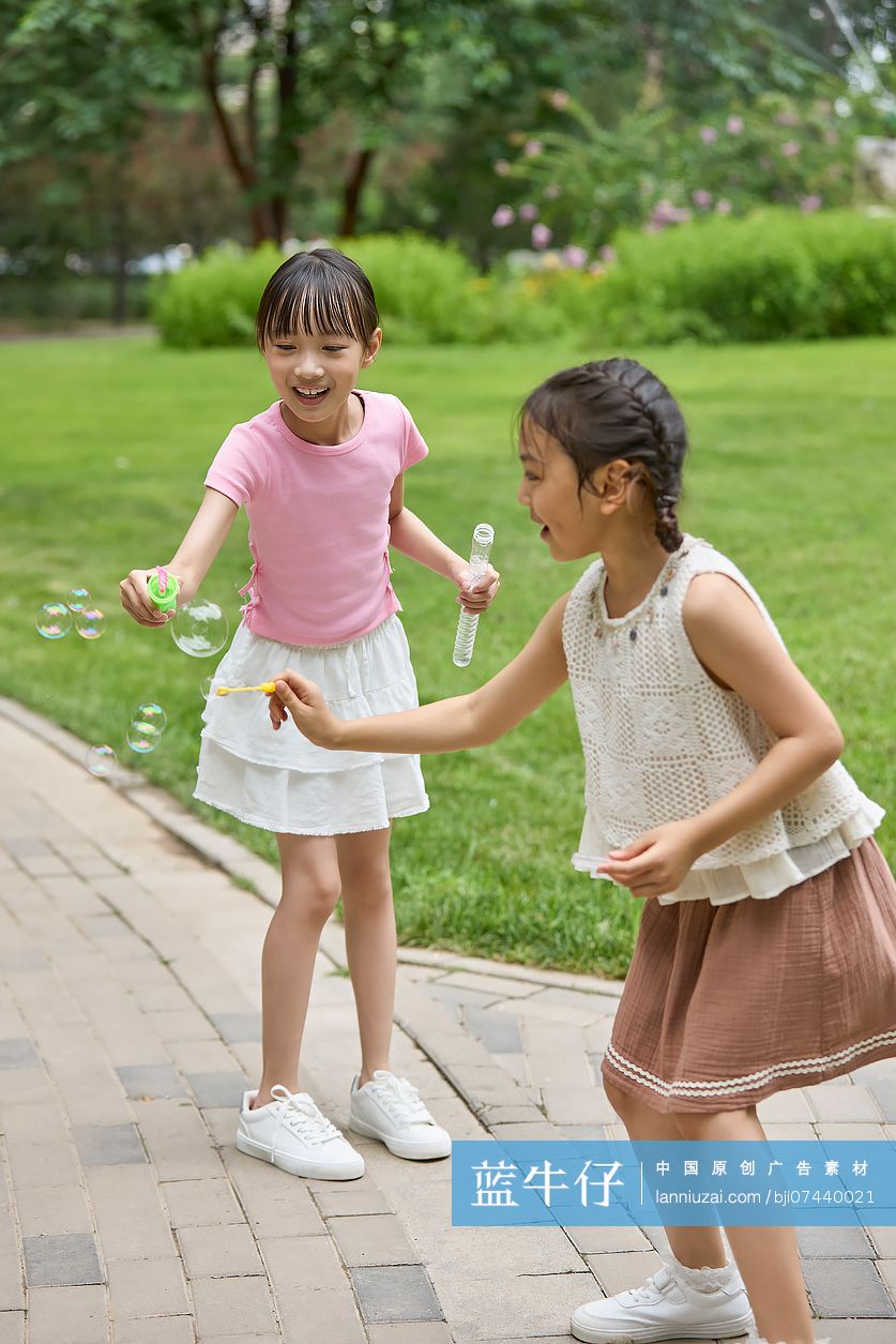 两个小女孩在公园吹泡泡