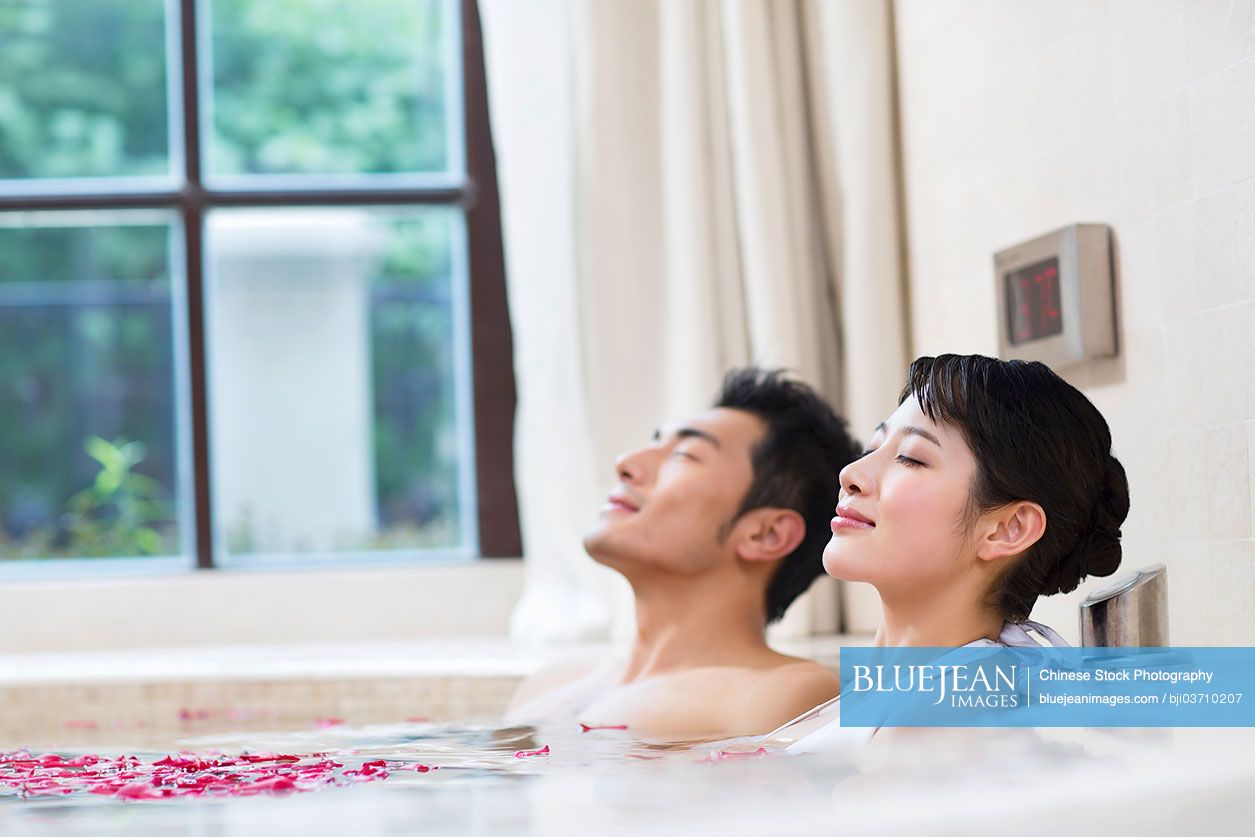 Sweet young Chinese couple relaxing in a nice hot bath