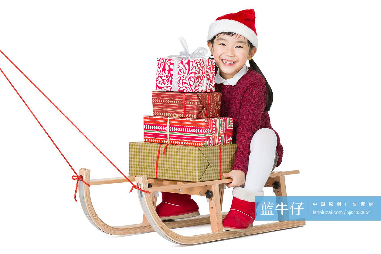 小女孩拿着圣诞礼物坐在雪橇上