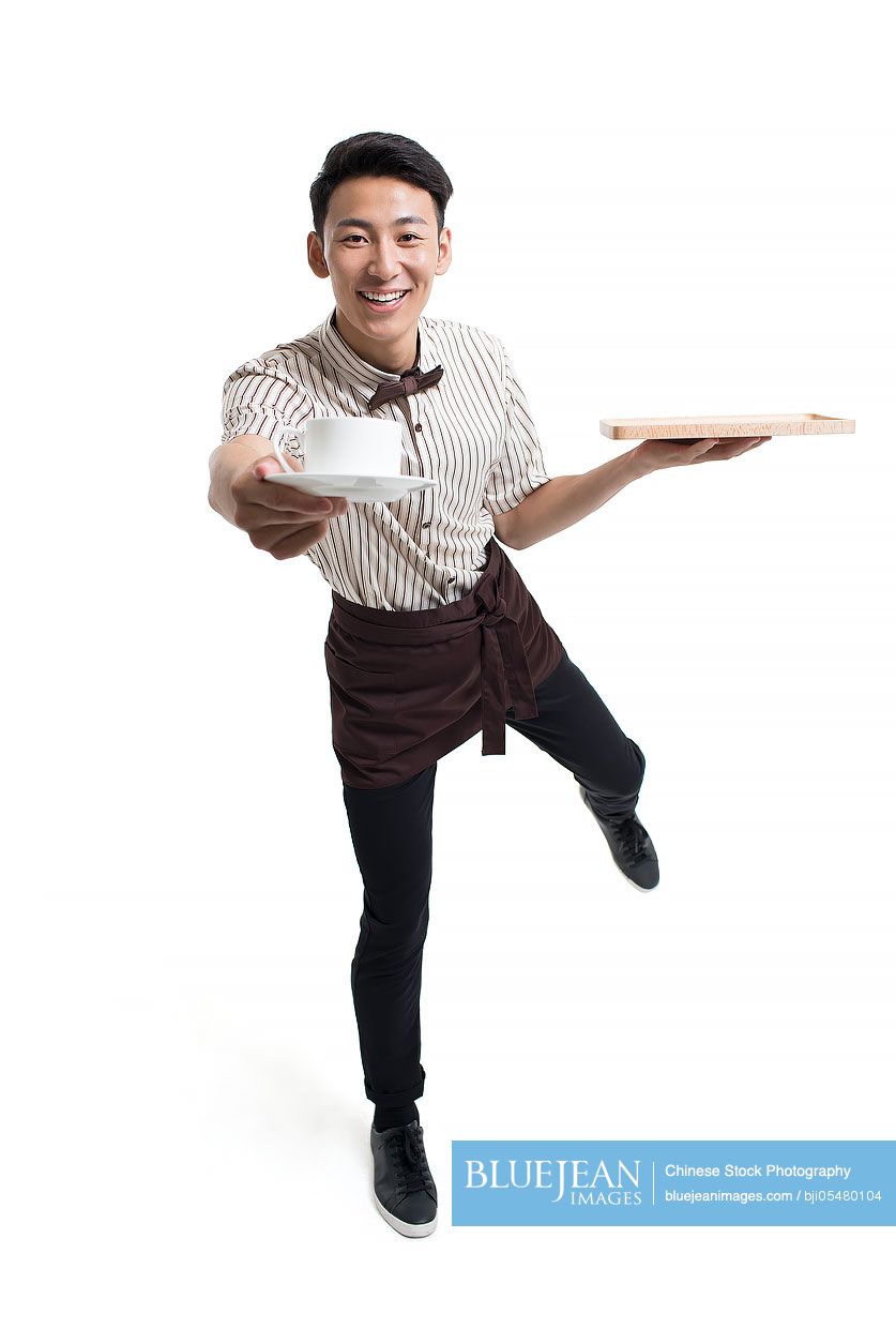 Young Chinese waiter holding a cup of coffee