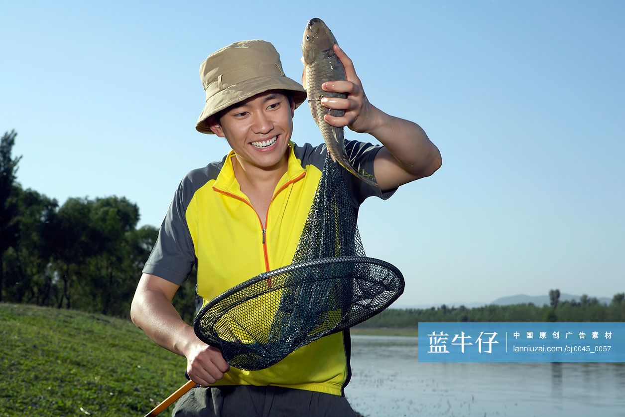 年轻男子在河边捕鱼