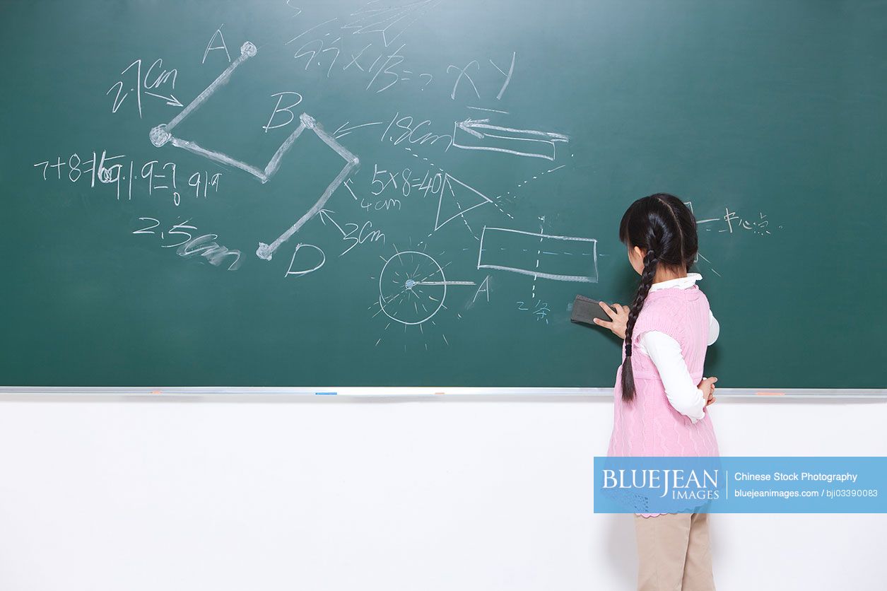 Chinese schoolgirl cleaning the blackboard in classroom