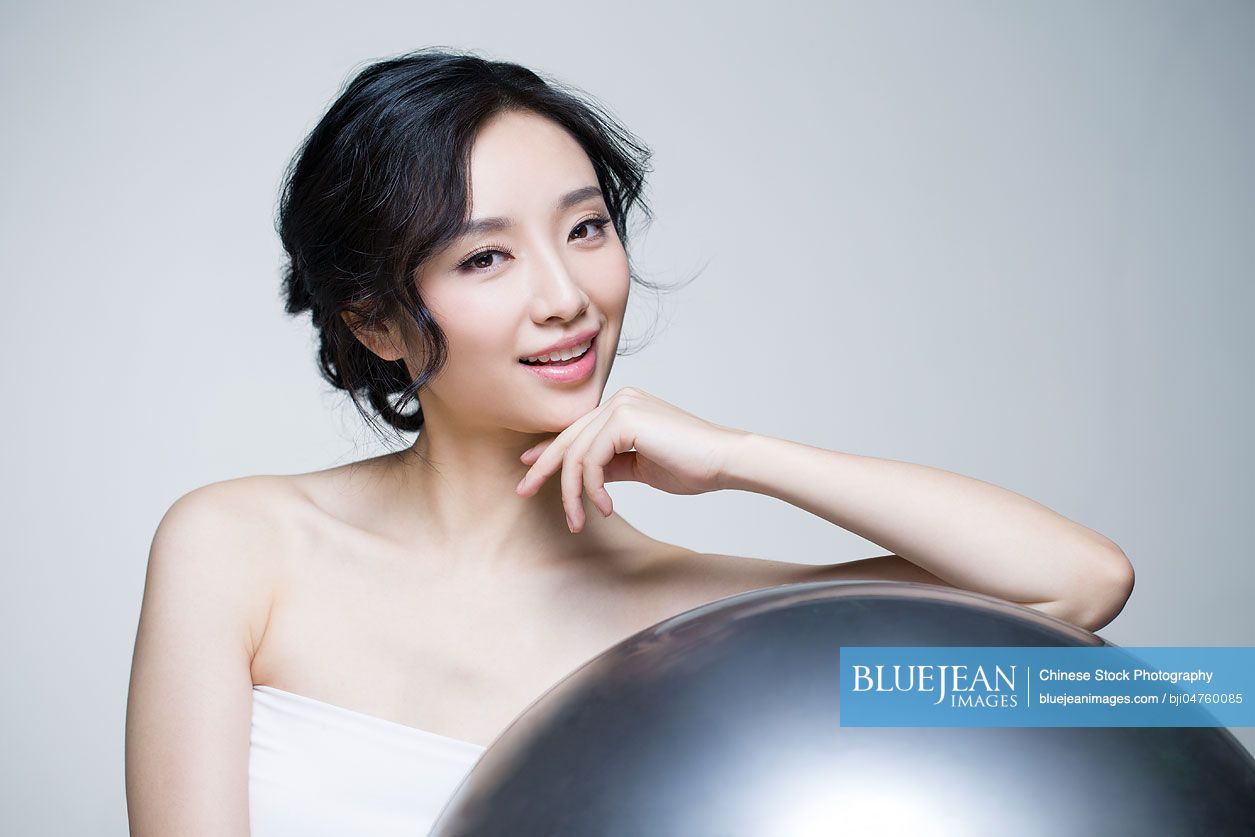 Beautiful young Chinese woman with fitness ball